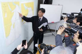 Mluvčí jihokorejského námořnictva ukazuje místo zásahu na mapě.