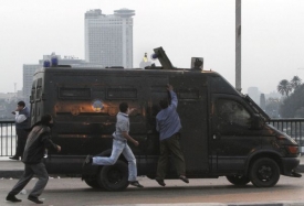 Mladíci hážou do obrněného vozu policie Molotovův koktejl.