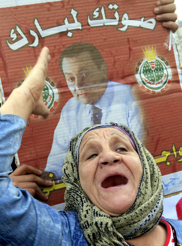 Postarší zastánkyně Mubaraka výkřikuje během pochodu v Káhiře slogany na jeho obranu. Egyptské úřady bojují za záchranu prezidenta řadou ústupků a slibů občanům.