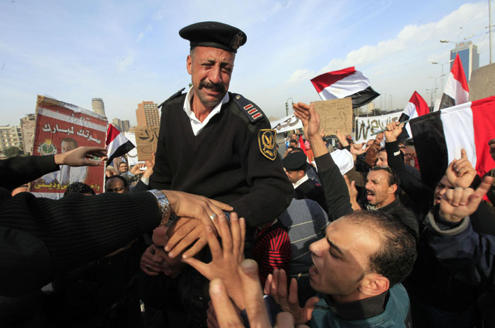 Egyptský policista pláče dojetím poté, co se mu dostalo vřelého uvítání od demonstrujících v ulicích Káhiry. Před třemi dny se policie stáhla z ulic města, aby následovala protestující proti Mubarakově vládě.