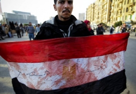 Demonstrant se zakrvavenou egyptskou vlajkou.