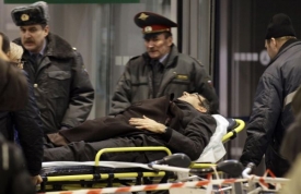 Zdravotníci odvážejí raněné po útoku na letišti Domodědovo.