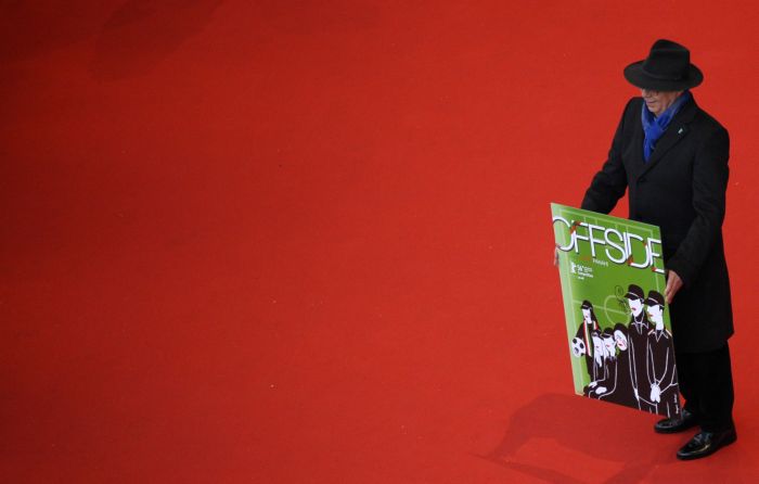 Ředitel festivalu Dieter Kosslick drží plakát k filmu Offside od íránského režiséra Jafara Panahi. 