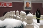 Čínští vojáci uklízejí z ulic sníh.
