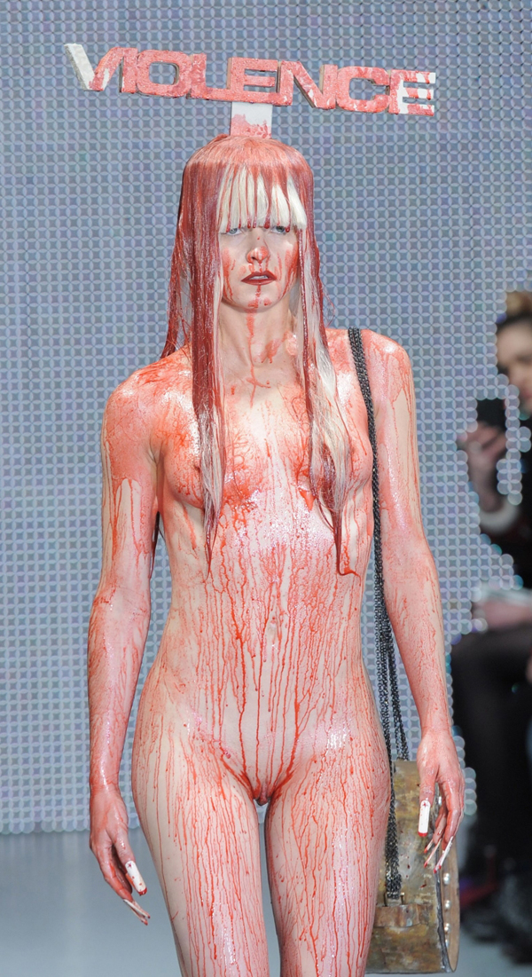 Na molu se objevila i zcela nahá modelka politá červenou barvou. V pozadí výmluvný nápis Violence (Násilí).