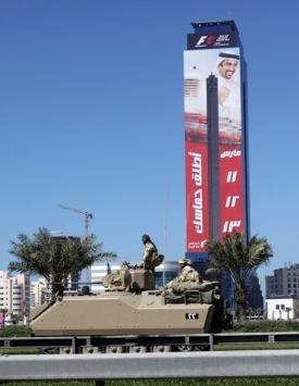 Pod obřím poutačem lákajícím na Velkou cenu Bahrajnu projíždějí tanky.