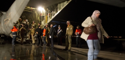 Evakuovaní lidé vystupují z vojenského letadla C-130 v Římě.