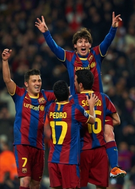 Lionel Messi nad hlavami spoluhráčů oslavuje postupový gól z penalty.