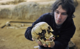 Archeolog Tomáš Chrástek s lebkou.