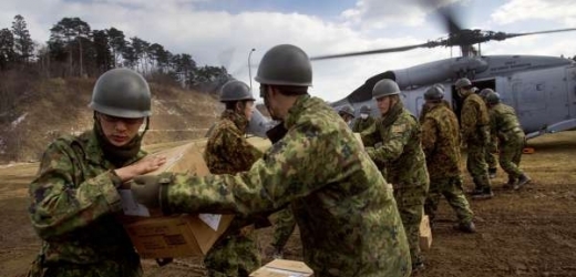 Japonští vojáci distribuují americkým vrtulníkem potraviny do postižené oblasti.