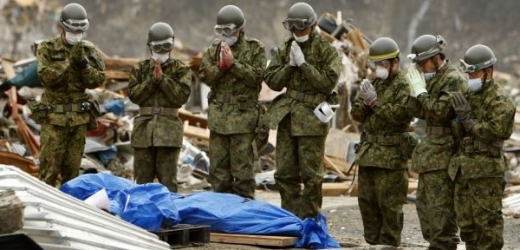 Příslušníci japonské armády nad těly obětí ničivého tsunami.