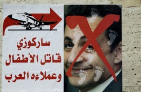 Plakát na ulici v Tripolisu. Francouzský prezident Sarkozy se kvůli svému angažmá na straně rebelů stal terčem Kaddáfího propagandy.