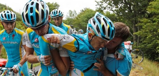 Členové týmu Astana odnáší zraněného Alexandra Vinokurova do sanitky.