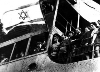 Židovští uprchlíci mířící do Palestiny zpívají roku 1946 hymnu na palubě lodi Empire Royal.