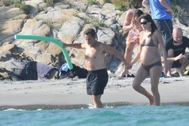 Těhotná Carla Bruniová na pláži se svým manželem.