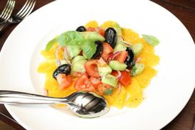 Pomerančový salát s olivami, okurkou, rajčaty a bazalkou.