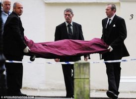 Tělo Amy Winehouse vynášené z domu.
