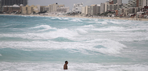 Muž plave po odeznění bouře Don u pláže Gaviota Azul v Mexiku. Odsud míří bouře do Texasu.