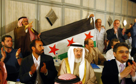 Zástupci opozice s vlajkou první syrské republiky z doby před pučem strany Baas.