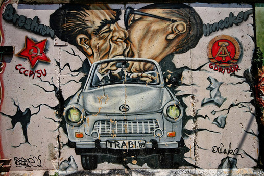 Slavný polibek mezi sovětským vůdcem Leonidem Brežněvem (vlevo) a východoněmeckým vůdcem Erichem Honeckerem v tzv. Galerii East Side. Jde o 1,3 kilometru dlouhou část Berlínské zdi. Tento konkrétní úsek zdobí kresby a politická prohlášení z roku 1990.