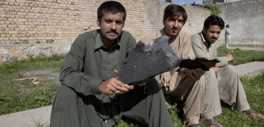 Pákistánci v Abbotabádu s úlomkem z torza "neviditelné" americké helikoptéry.