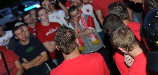 Hráči Slavie (zády v červených trikách) vysvětlují fanouškům současné výsledky.
