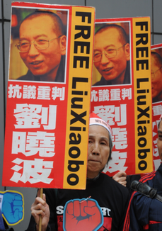 Demonstrantka ze propuštění Pekingem vězněného laureáta loňské Nobelovy ceny míru Lioua Siao-poa.