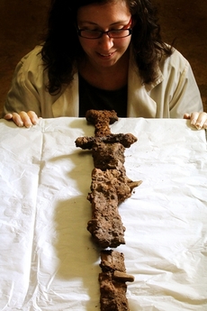 Archeoložka Hannah Cobbová ukazuje meč, který byl součástí pohřební výbavy.