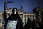 Kmotřička Smrt si brousí kosu na finančníky před Spolkovým sněmem v Berlíně.