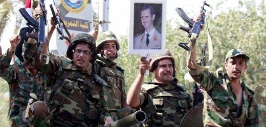 Syrští vojáci s portréty prezidenta Asada.