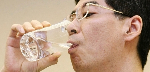 Poslanec Jasuhiro Sonoda hltá vodu odčerpanou z poškozených reaktorů.