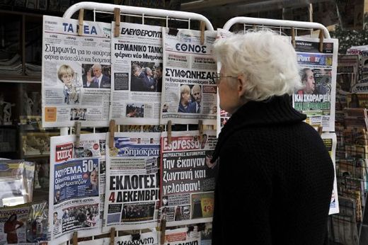 Obyvatelka Atén čte v novinách o čerstvém vývoji krize.