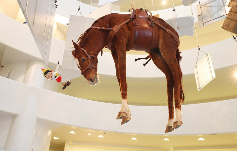 Mezi exponáty zavěšenými na provázcích je i vycpaný kůň nebo oblíbená dětská postavička Pinocchia (v pozadí).