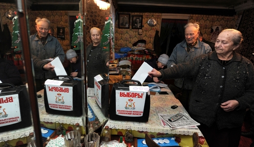 Voliči se vidí v zrcadlech ve volební místnosti u Smolenska.