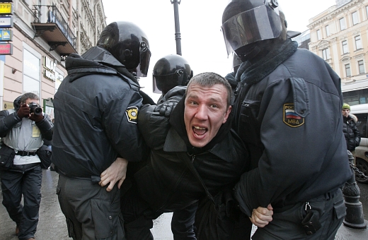Policie se zadrženým demonstrantem během protestů v Petrohradu.