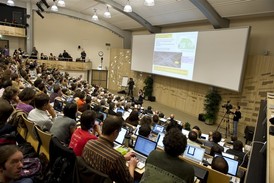 Fyzikové na semináři v CERN sledují prezentaci kolegů z experimentů ATLAS a CMS.