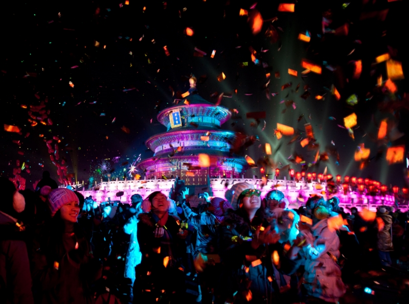 Lidé v Pekingu sledují světelnou show a padající konfety před Chrámem nebes. (Foto: ČTK/AP)