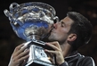 Světová jednička Novak Djokovič líbá trofej pro vítěze Australian Open.
