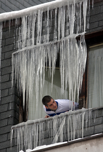 Muž si prohlíží rampouchy kolem svého okna v Uzici, asi 200 kilometrů jihozápadně od srbského Bělehradu. Nejméně 11 tisíc vesničanů bylo uvězněno v těžkém sněhu a vánici v srbských horách. Úřady ve čtvrtek oznámily, že počet obětí mrazivého počasí ve východní Evropě vzrostl za týden na 122. (Foto: ČTK/AP)