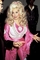 Zpěvačka Dolly Partonová v roce 1977, kdy vypadala s blond hřívou, v růžovobílých šatech a spoustou make-upu doslova jako Barbie. 