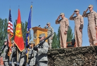 Američtí vojáci vzdávají hold kyrgyzské vlajce.