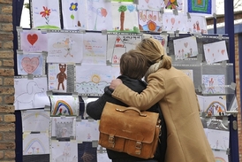 Student s maminkou si prohlížejí obrázky namalované pro oběti nehody.