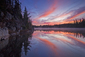 Červánky nad jezerem Line v kanadském Ontariu vytvářejí na vodní hladině rozbíhající se barevné brázdy.