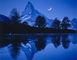 Působivý vodní odraz švýcarské hory Matterhorn v noci.