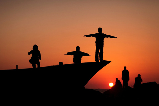 Palestinci pozorující západ slunce v Gaze. (Foto: profimedia.cz)