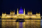 Turistická loď na Dunaji před osvětlenou budovou parlamentu v Budapešti. (Foto: ČTK/AP)