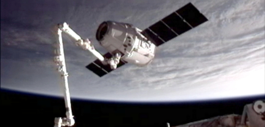 Dragon zachycený robotickým ramenem ISS.
