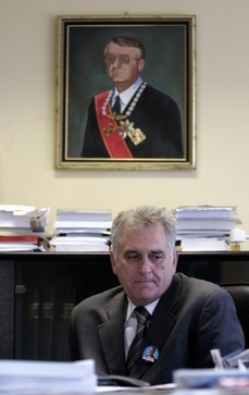 Nikolič pod portrétem svého politického mentora Vojislava Šešelje, který se v Haagu zodpovídá z válečných zločinů.
