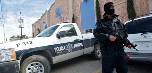 Policista v Ciudad Juarez chrání své kolegy ubytované v hotelu. 