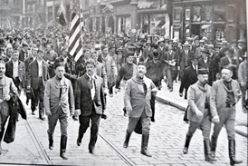 Průvod  sokolů centrem  Prahy, americkou vlajku nesou čeští sokolové z USA.